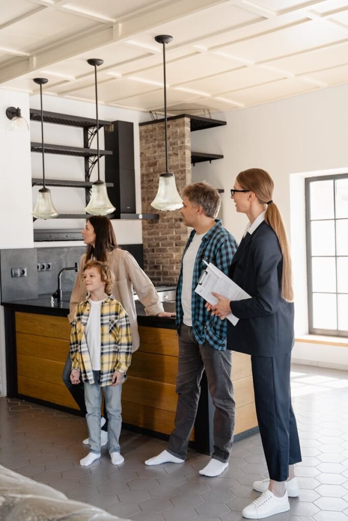pexels-photo-7415063-7415063 Family exploring a modern home kitchen with a real estate agent, showcasing buying opportunities.